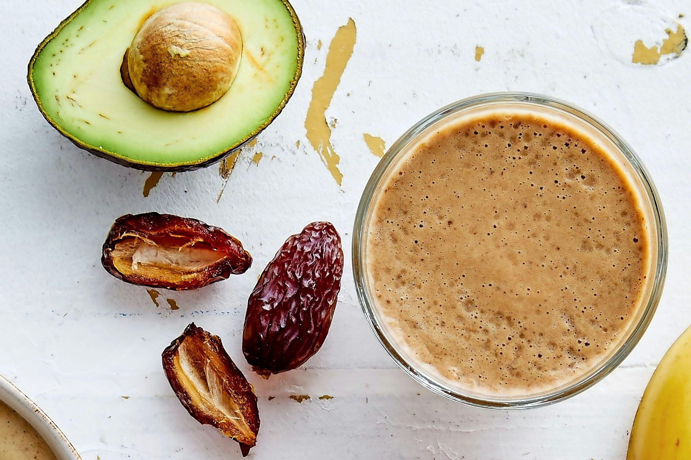 Glas med iskaffe och avokado och dadlar