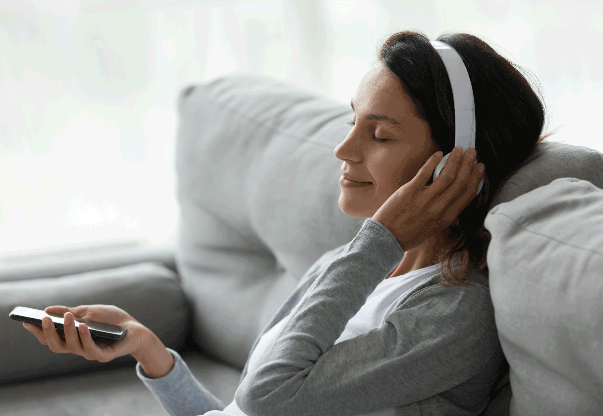 Kvinne mediterer i sofaen