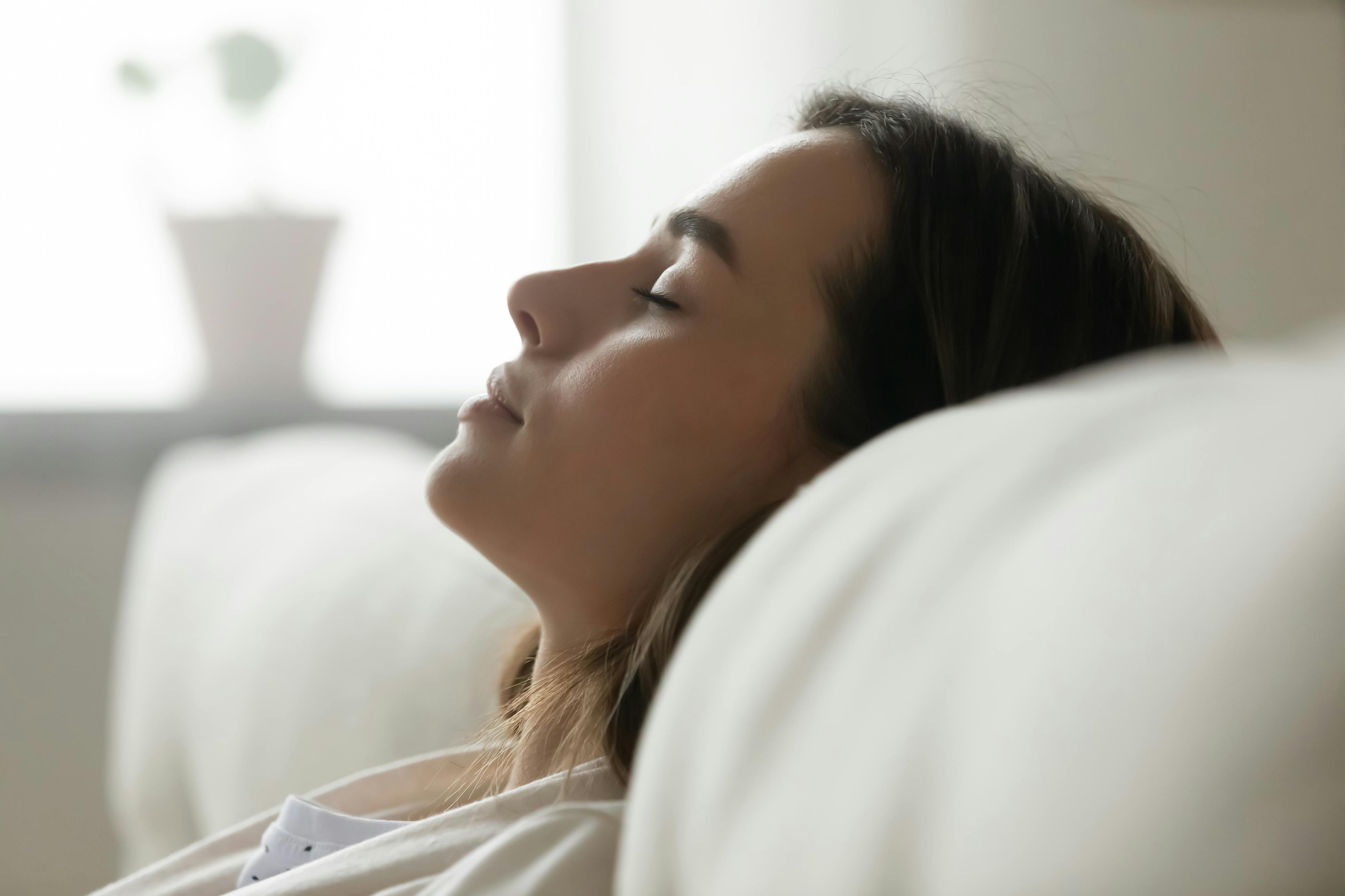 Nainen meditoi sohvalla