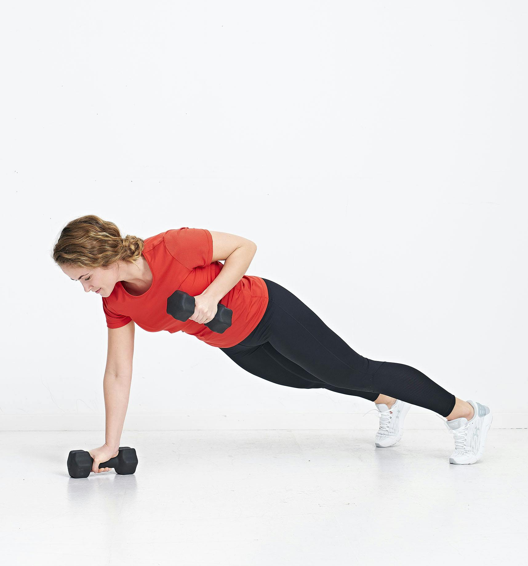 Kvinde laver øvelsen push-up med roning