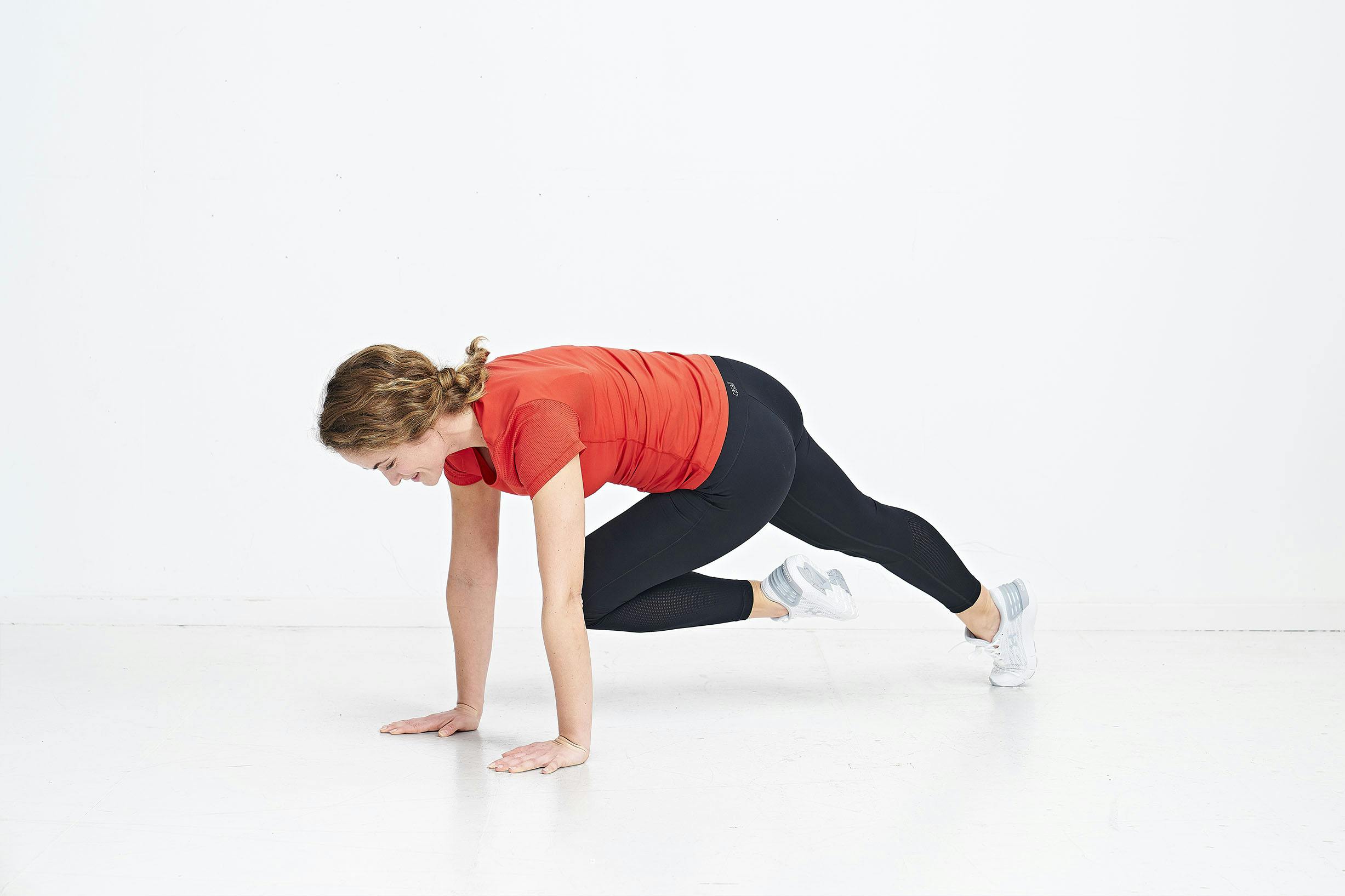 Kvinna gör pike push-up med mountain climbers