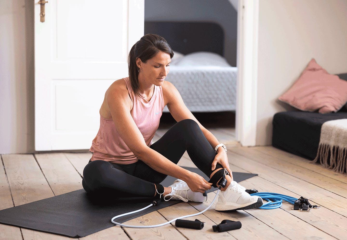 Nainen treenaa vastuskuminauhoilla kotona