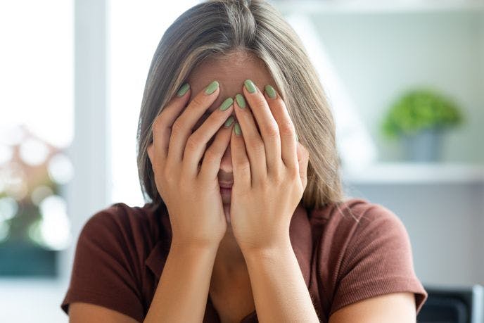 En konfliktsky kvinne som holder seg for øynene