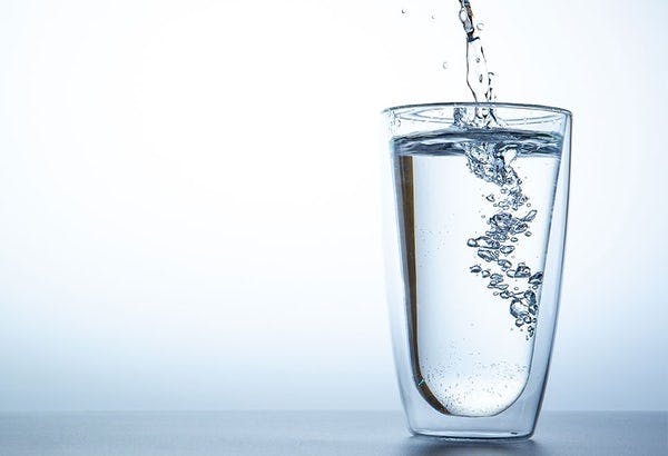 Vann i et glass til flat mage