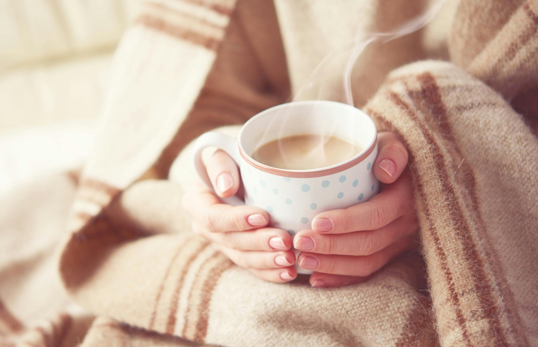 Kvinna dricker te mot förkylning och ont i halsen -