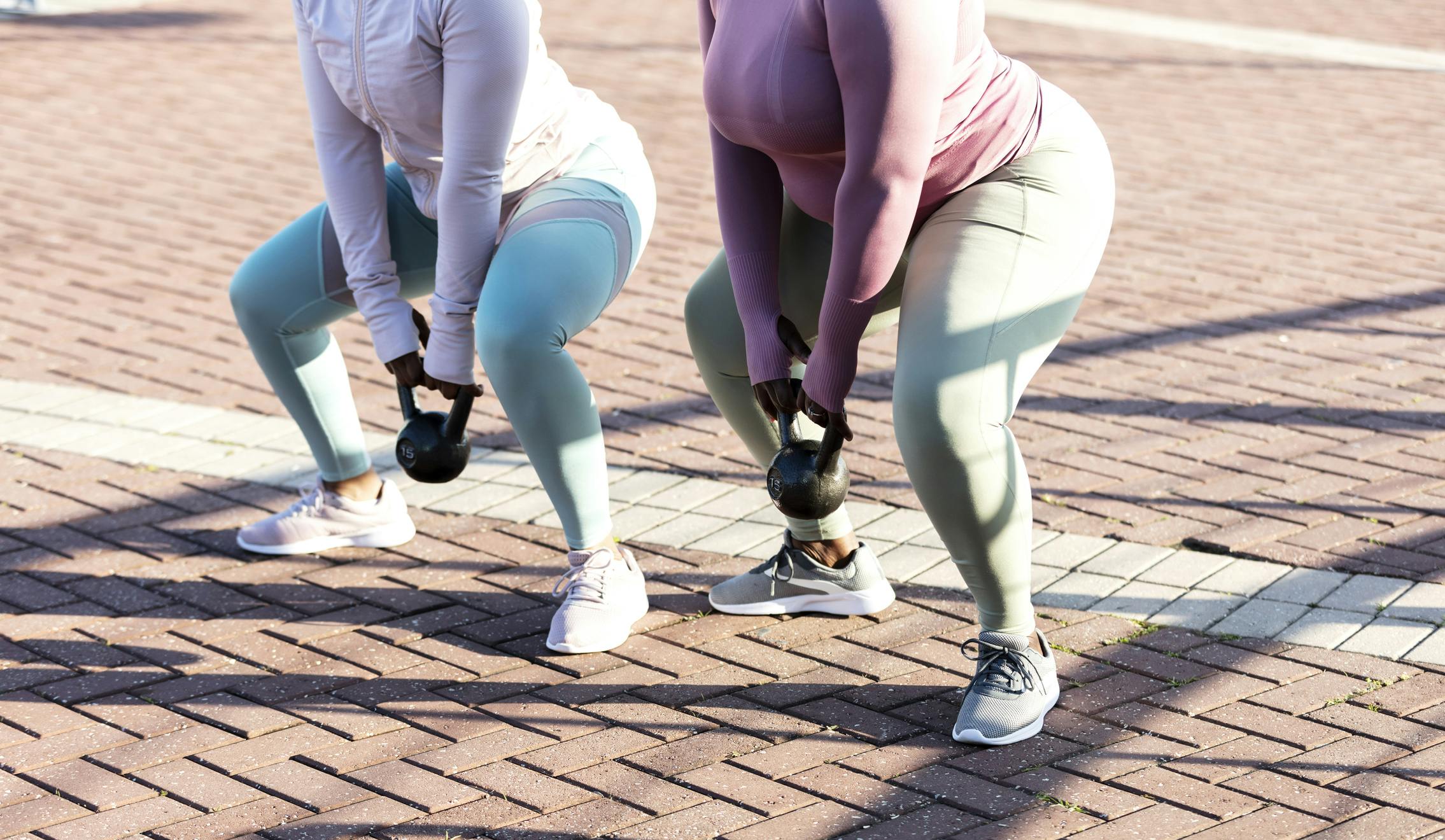 To kvinner gjør kettlebell sving.