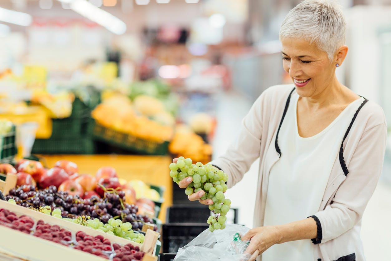 Moden kvinde i supermarkedet, køber frugt