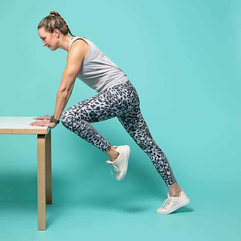 Bild av kvinna i träningskläder som gör stående moutain climbers