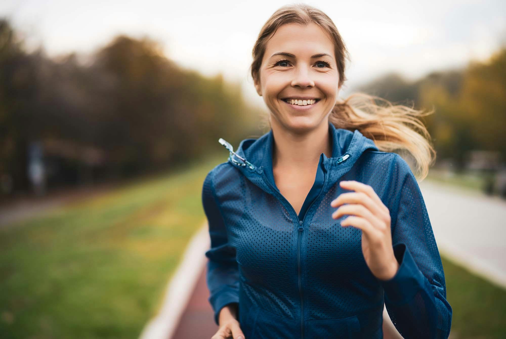 Kvinna som springer och ler