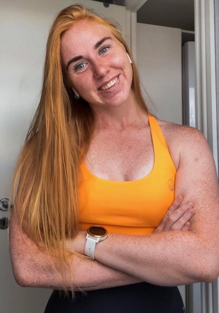 Ung kvinne i treningsklær og med armene i kors