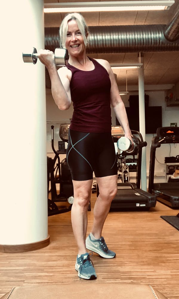 Kvinne i 50-årene trener med håndvekter