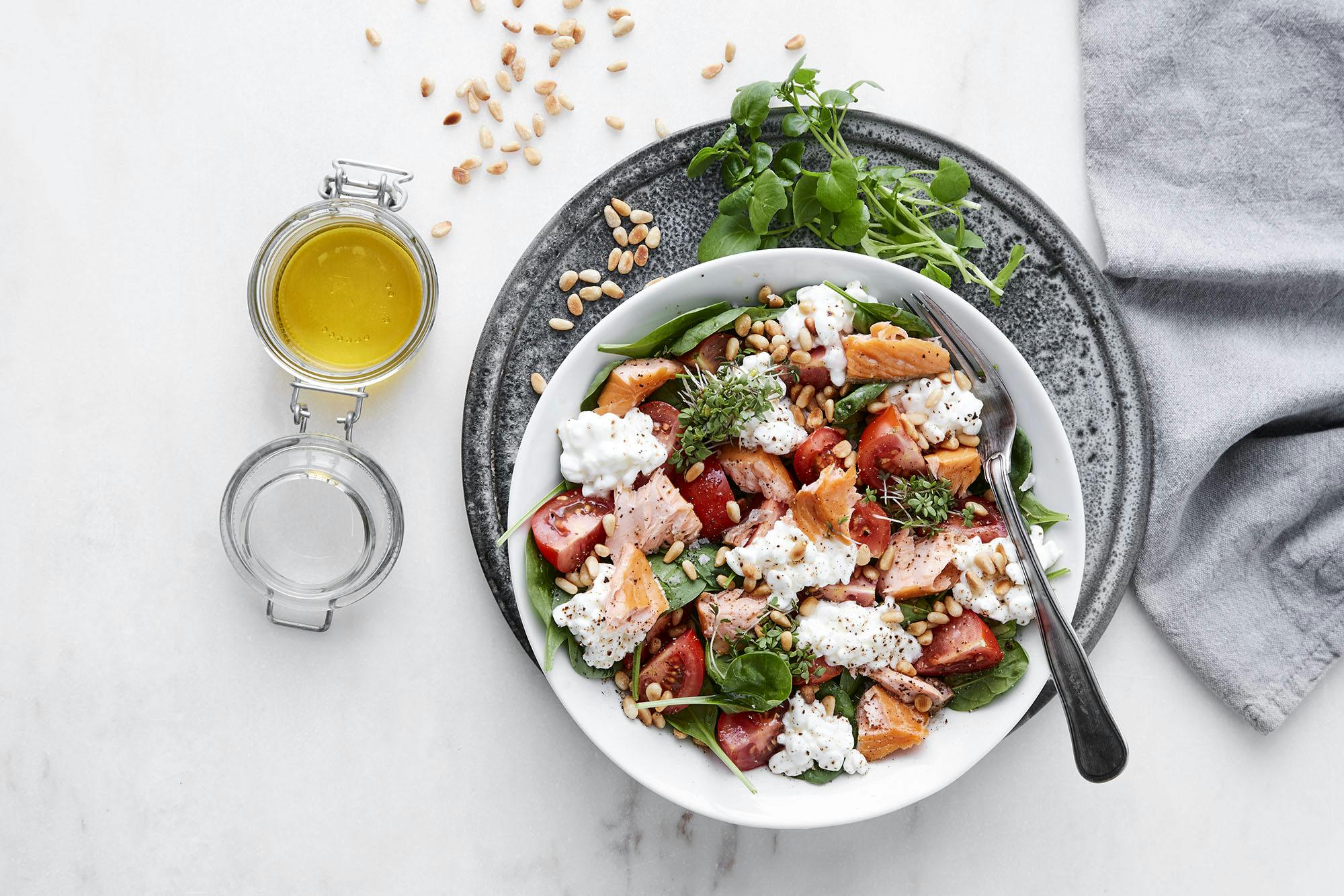 Spinatsalat med røykt laks, hytteost og pinjekerner