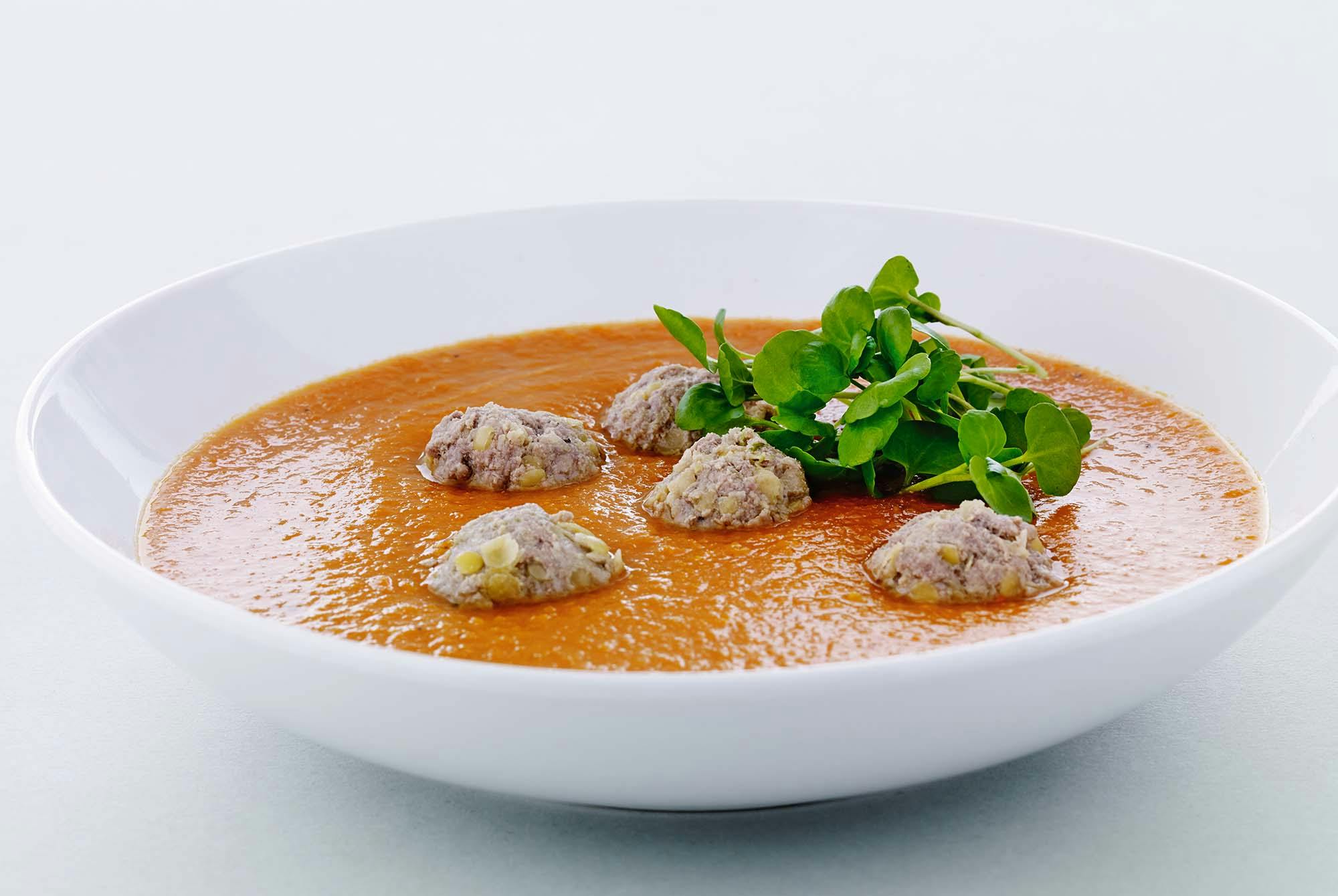 Skål med gulerodssuppe og kødboller