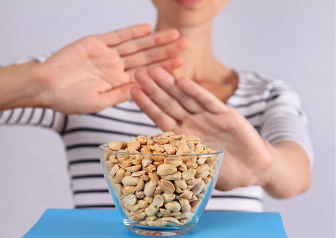 Kvinna avvisar en skål med jordnötter