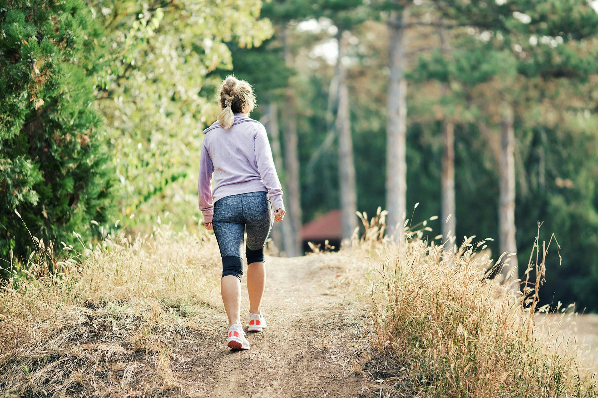 Kvinde går en tur, fordi bevægelse giver ny energi.