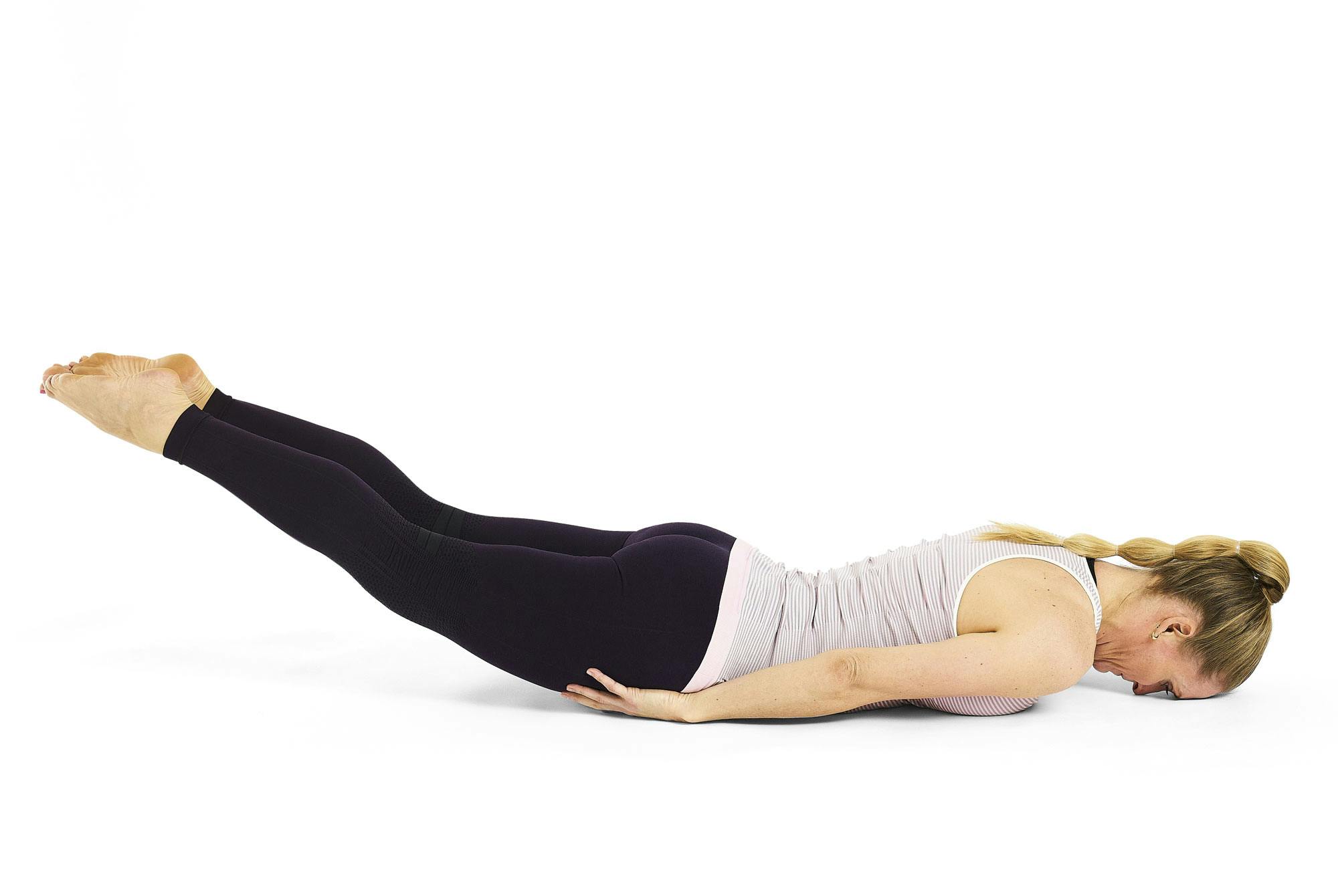 Kvinna gör yogaövningen gräshoppan