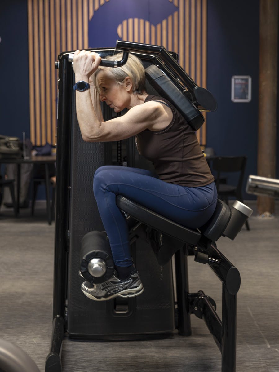 Kvinne gjør sit-ups i maskin