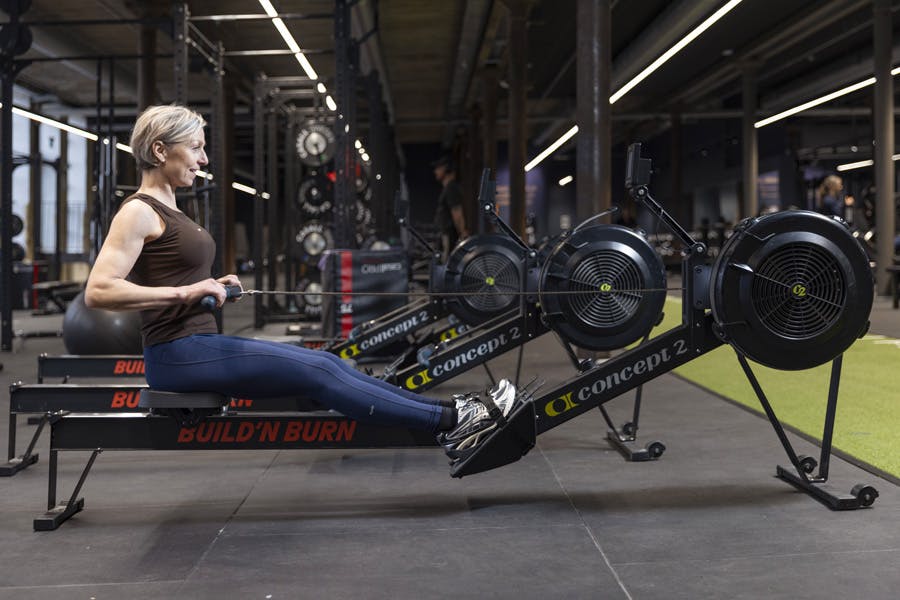 Kvinne på romaskin i treningssenteret