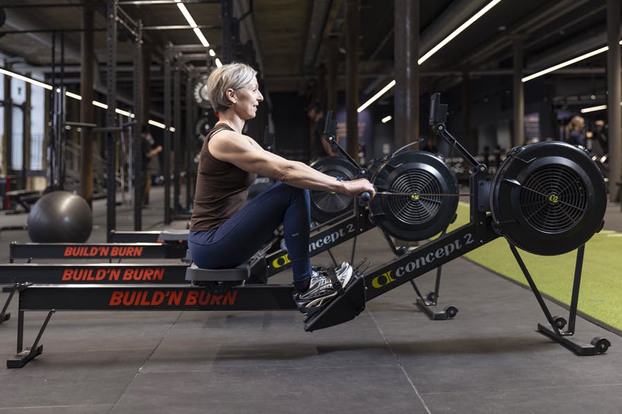 Kvinne på romaskin i treningssenteret