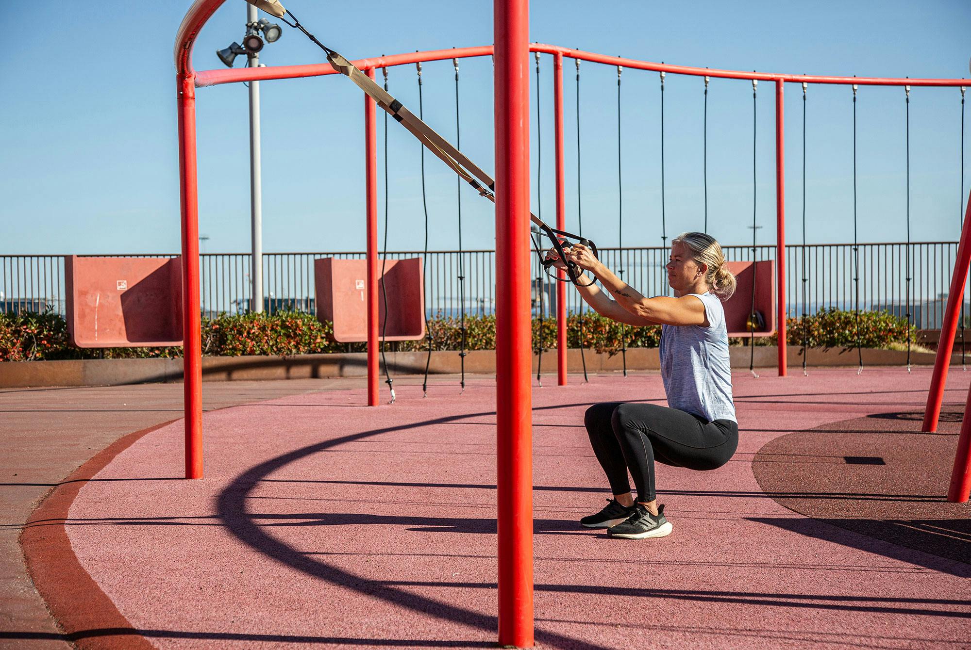 Kvinne gjør knebøy med slynge