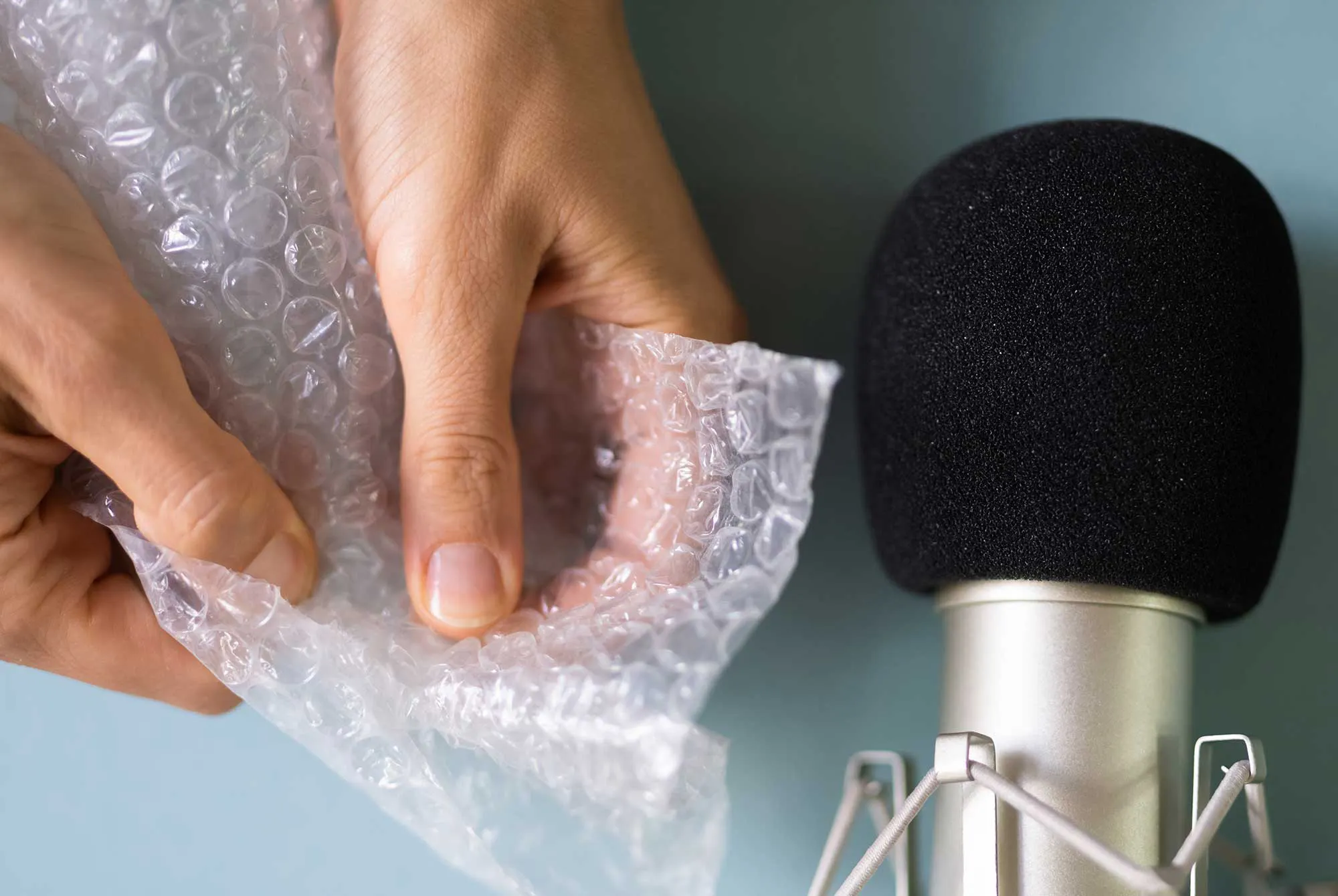 Fingre popper bobleplast foran mikrofon – eksempel på ASMR