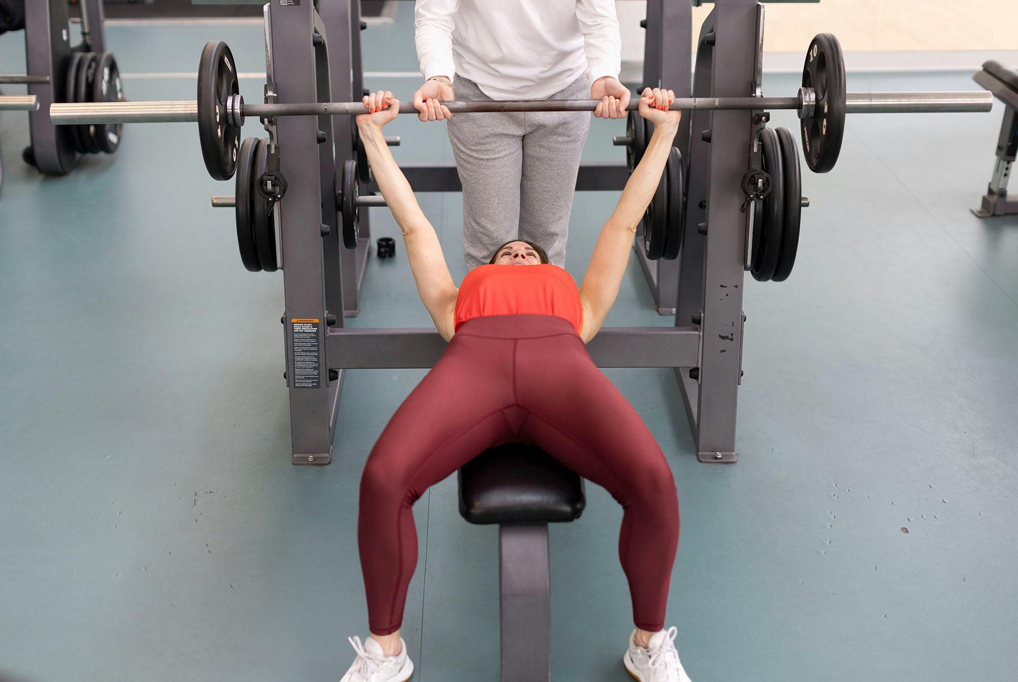 Benkpress med en spotter - en som kan hjelpe deg hvis du fortsatt ikke klarer å løfte stangen fra brystet
