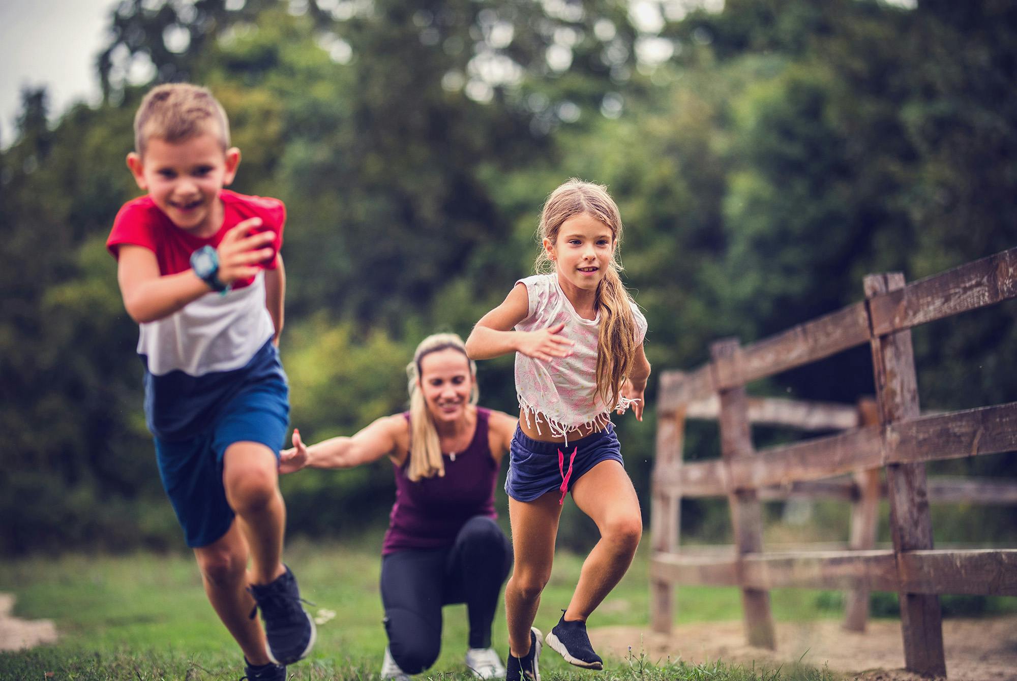Lapset juoksevat ja leikkivät äitinsä kanssa.