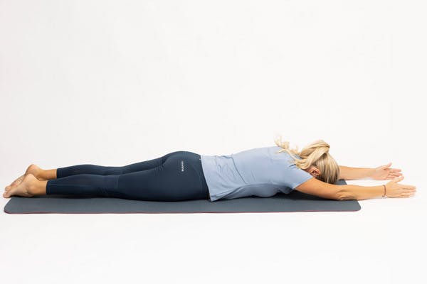 Kvinde laver øvelsen diagonalløft liggende