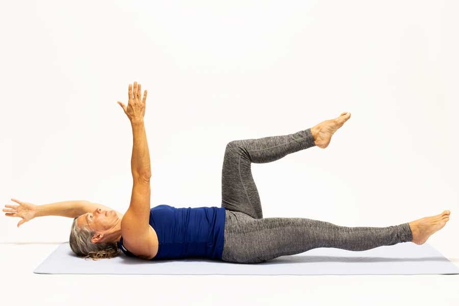 Kvinna gör övningen "död skalbagge"