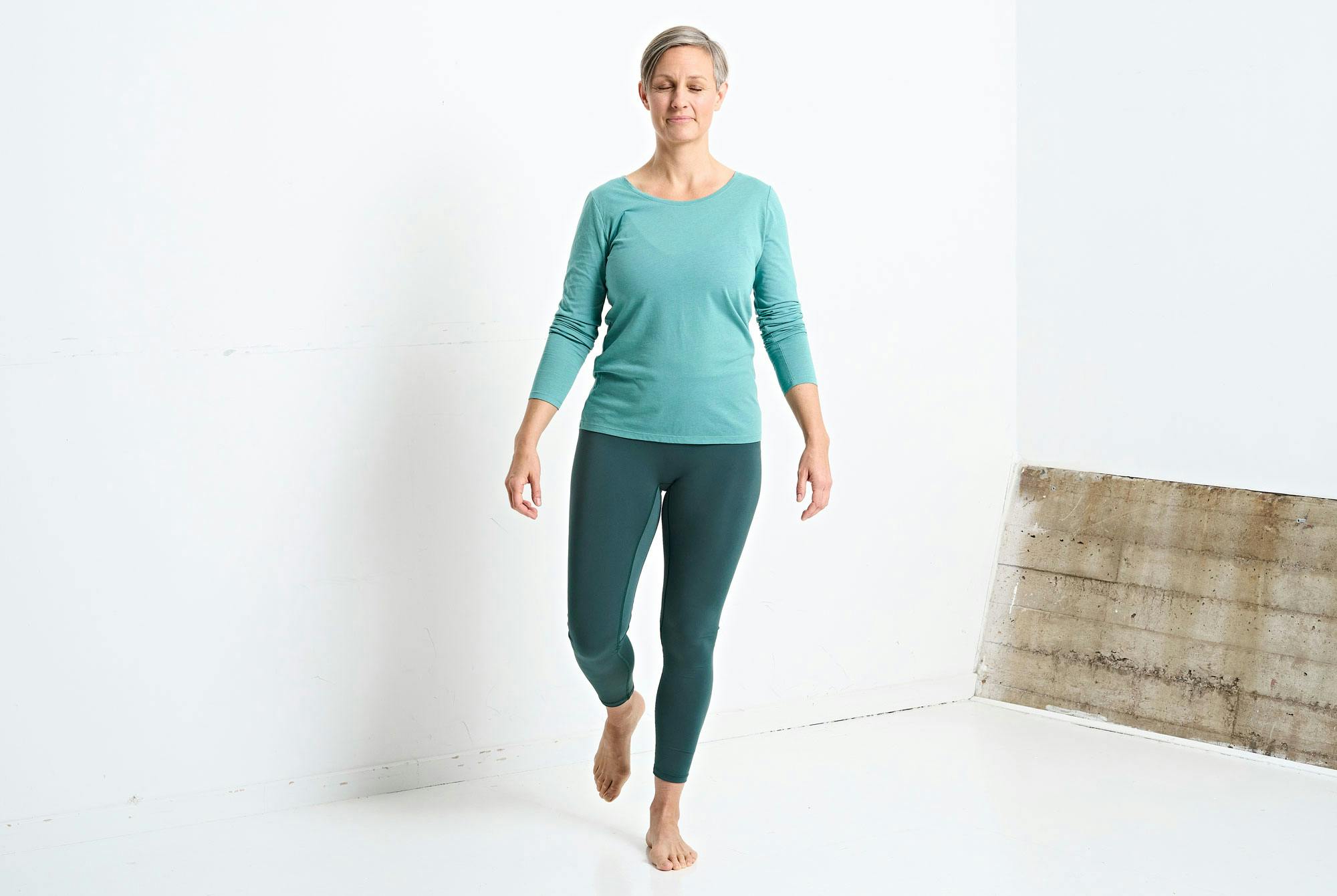 Nainen treenaa tasapainoilee yhdellä jalalla