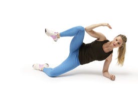 Kvinna gör övningen sidoplanka till sidoplanka crunch