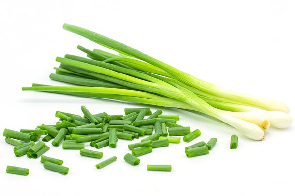 Et bundt forårsløg samt loidt snittet forårsløg