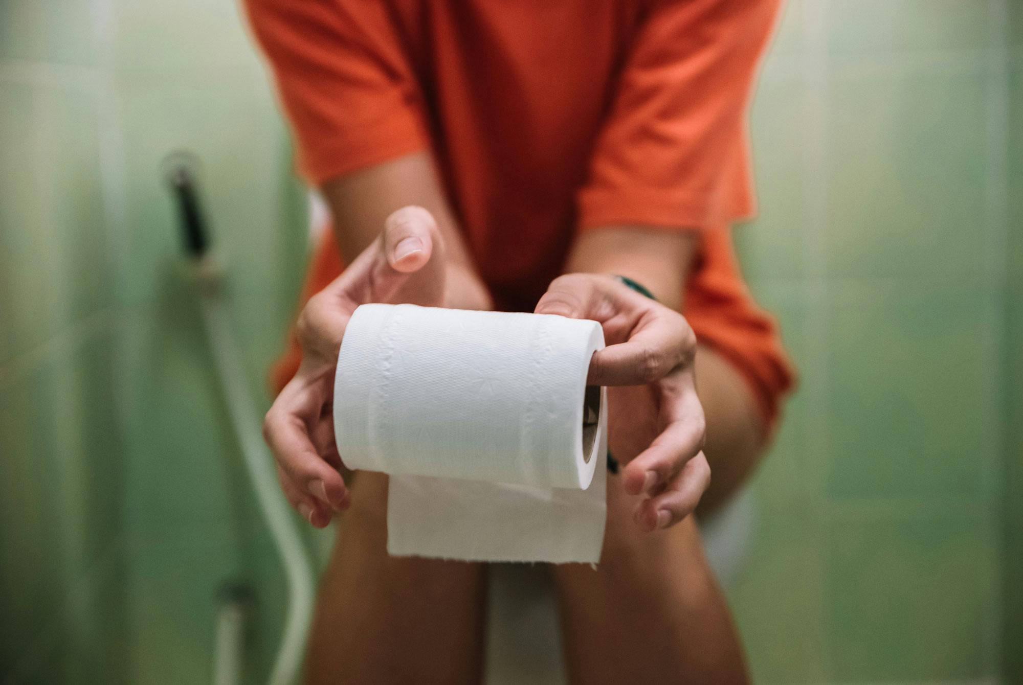 Kvinne sitter på toalettet, forstoppet