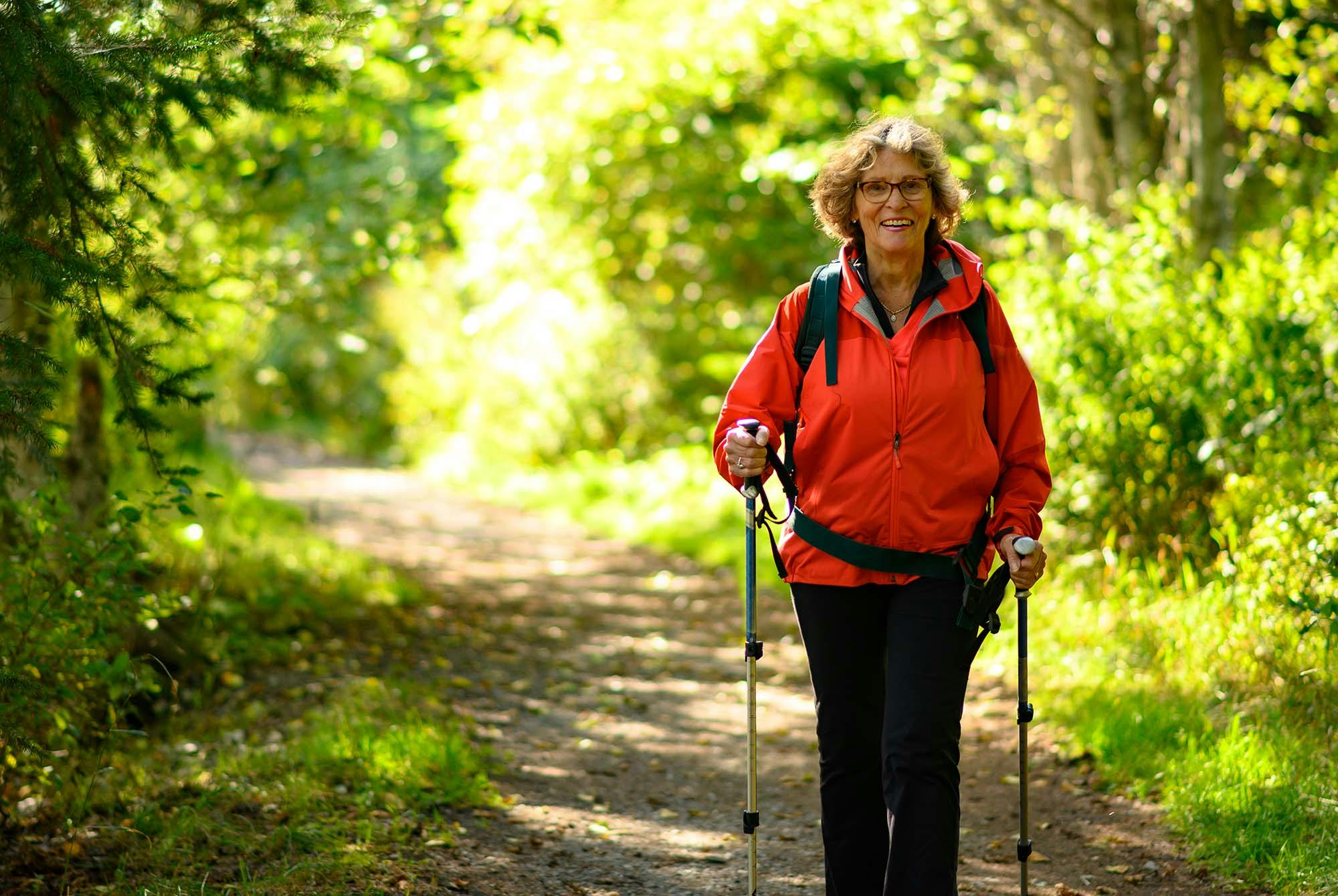 Middelaldrende kvinne på tur i skogen.
