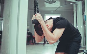 Man utför kneeling cable crunches i dragapparat