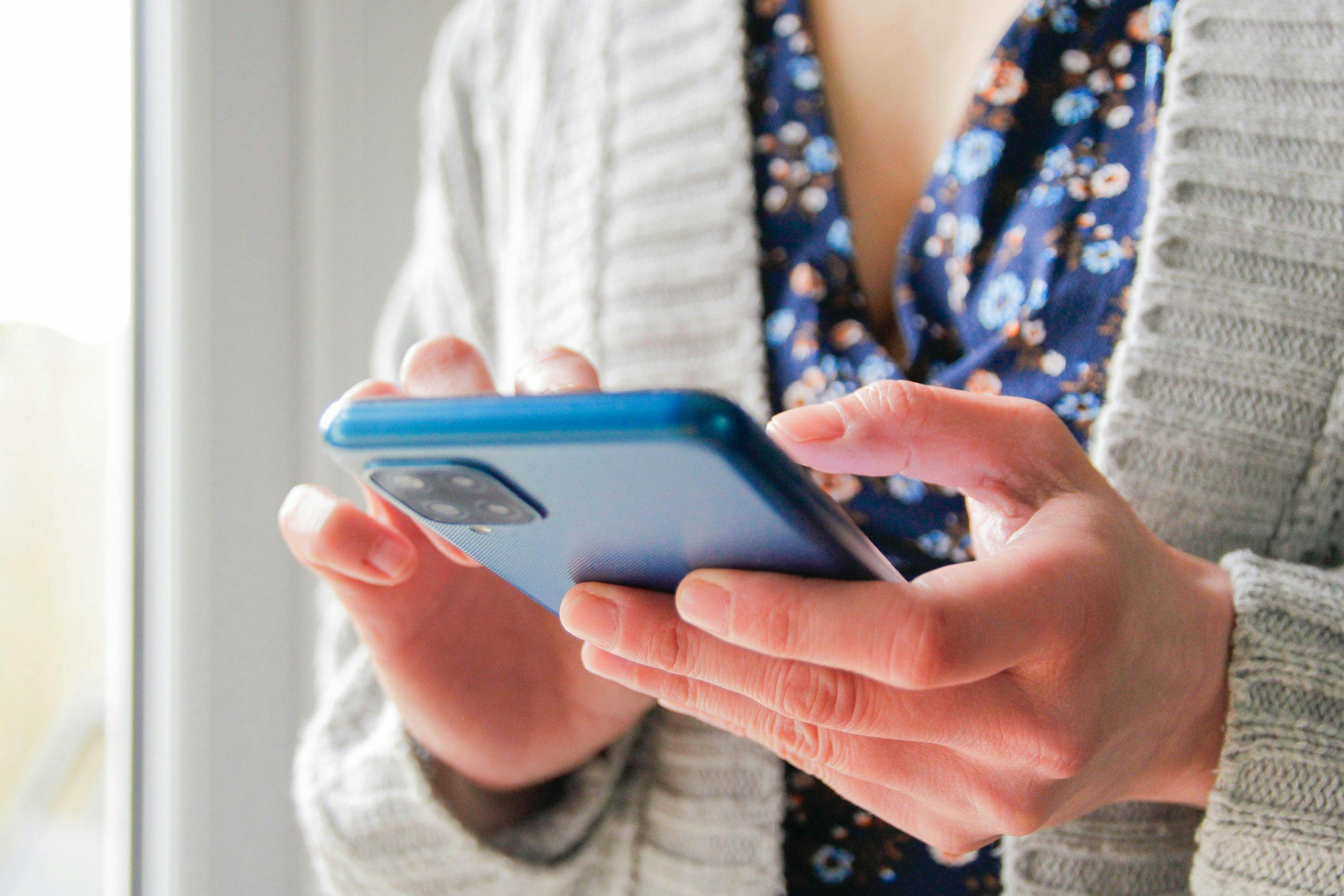 Kvinde holder en mobil i hånden.