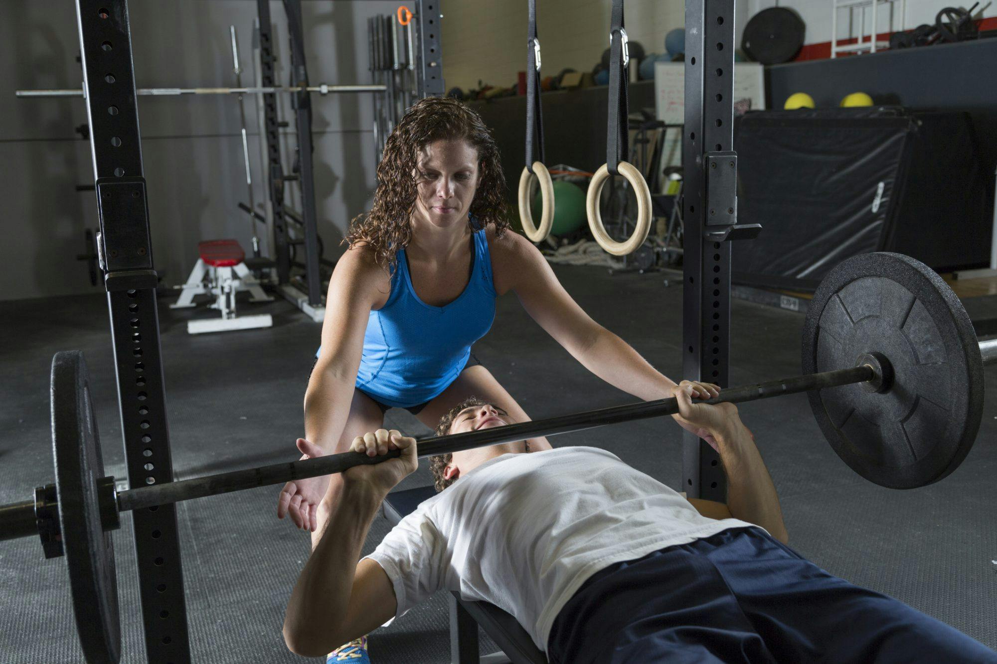 Kvinne og mann trener benkpress