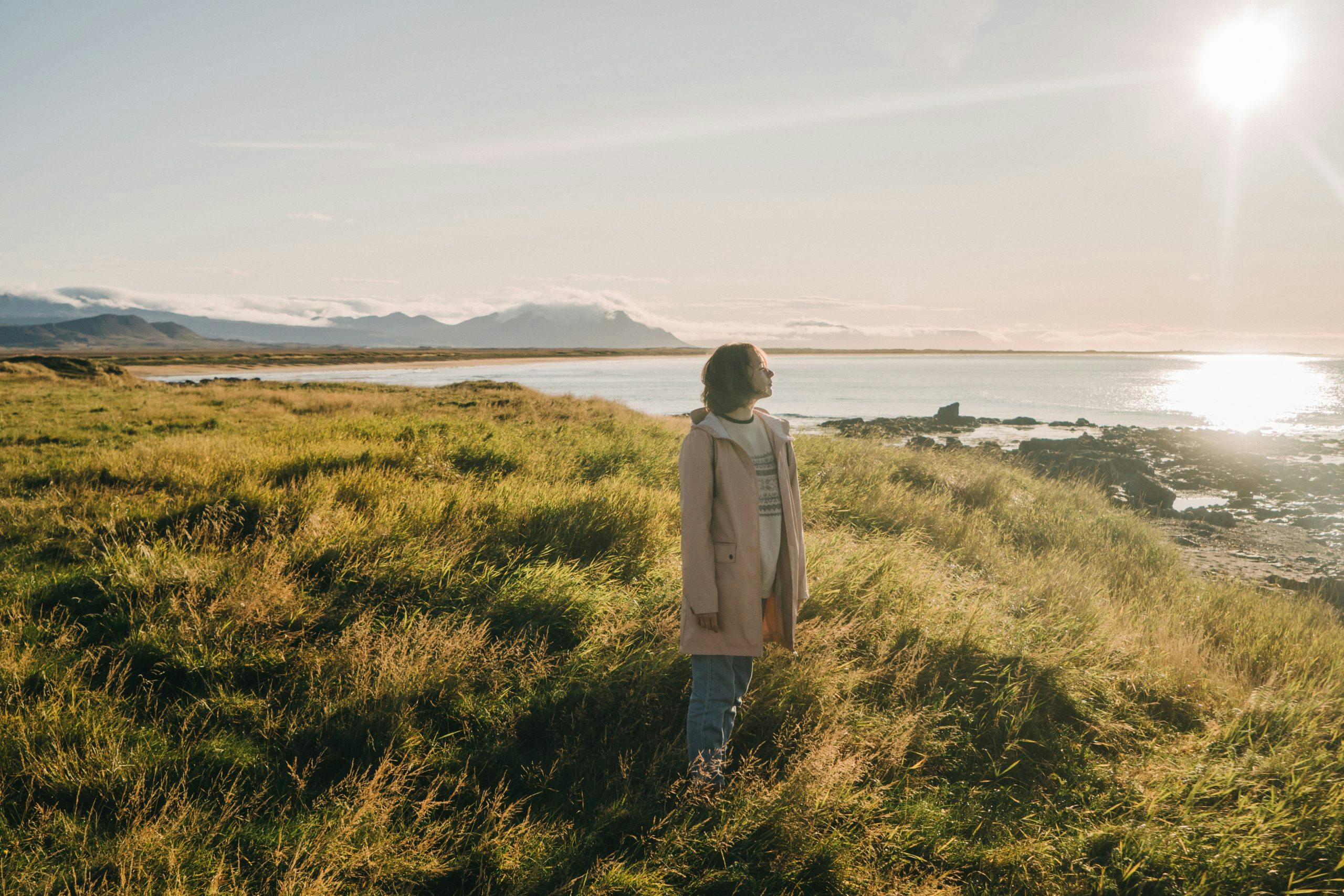 Kvinde kigger ud over havet. Hun har symptomer på perimenopause.