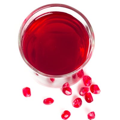 Et glass granateplejus og -kjerner