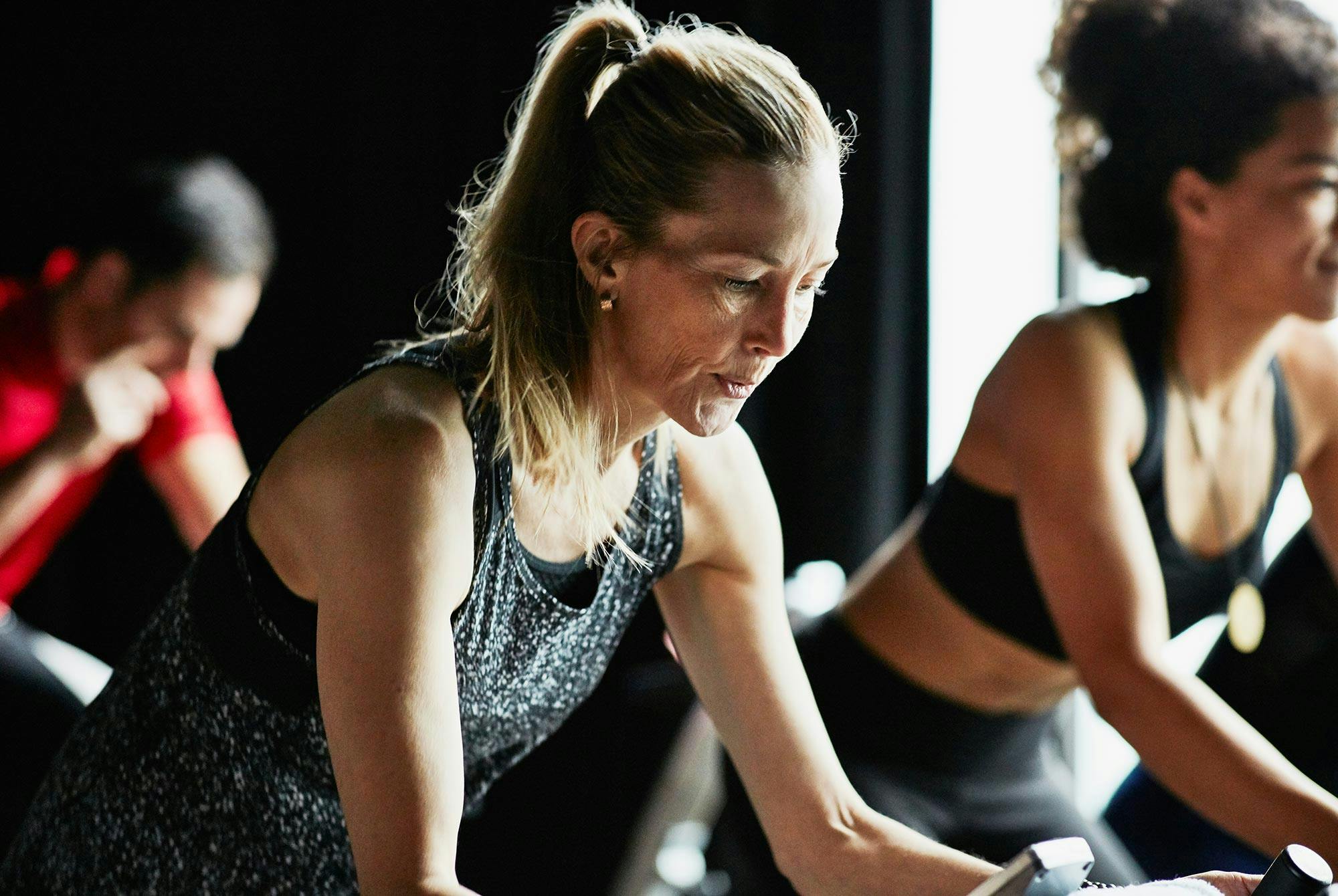 En kvinde er koncentreret på sin spinningcykel i en gymnastiksal. Hun er perfektionistisk.