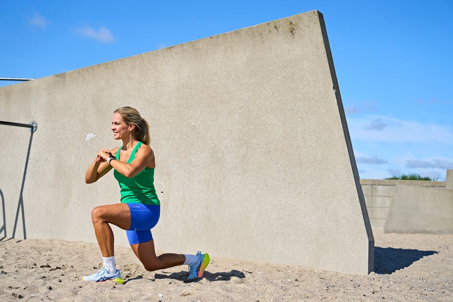 Kvinde laver HIIT-øvelse på strand