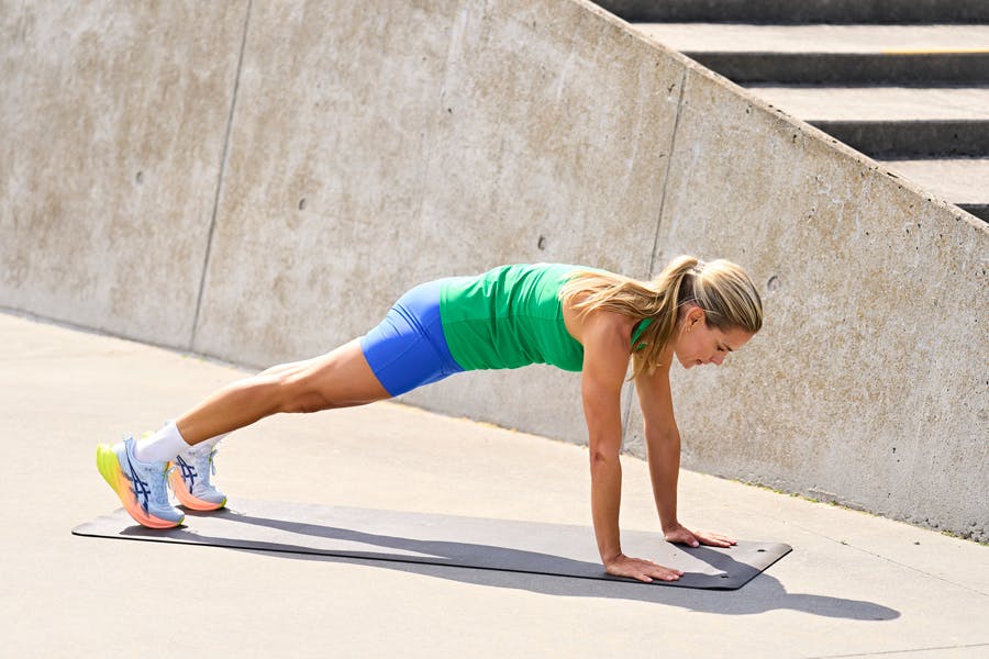 kvinde viser HIIT øvelse