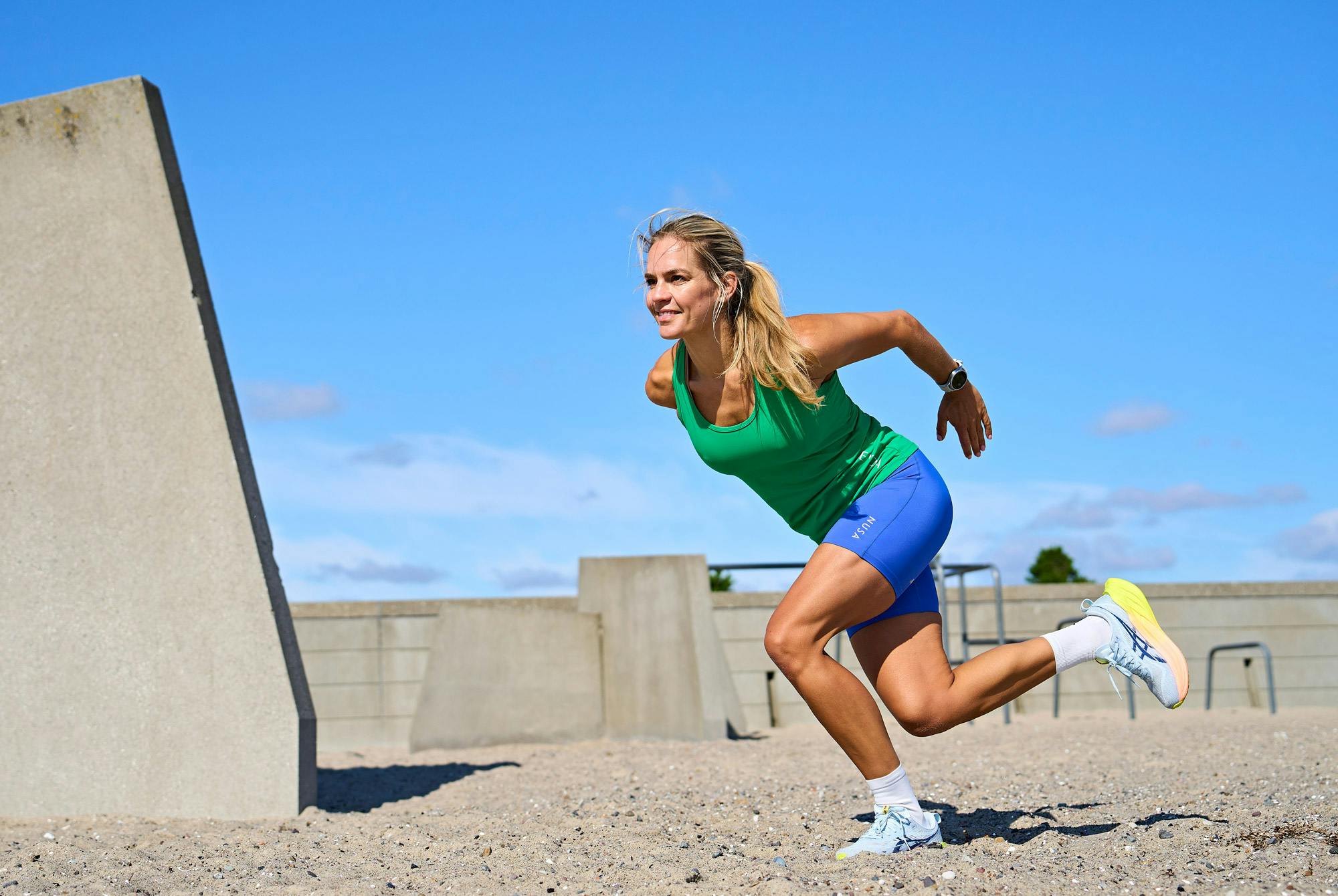 Nainen tekee HIIT-treeniä rannalla – HIIT-treeni