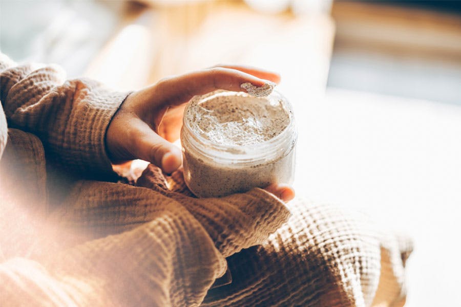 Kvinna med kroppsskrubb i händerna