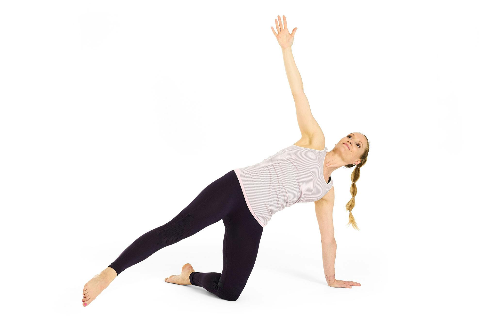 Kvinde laver yogaøvelsen halvmånen på knæ