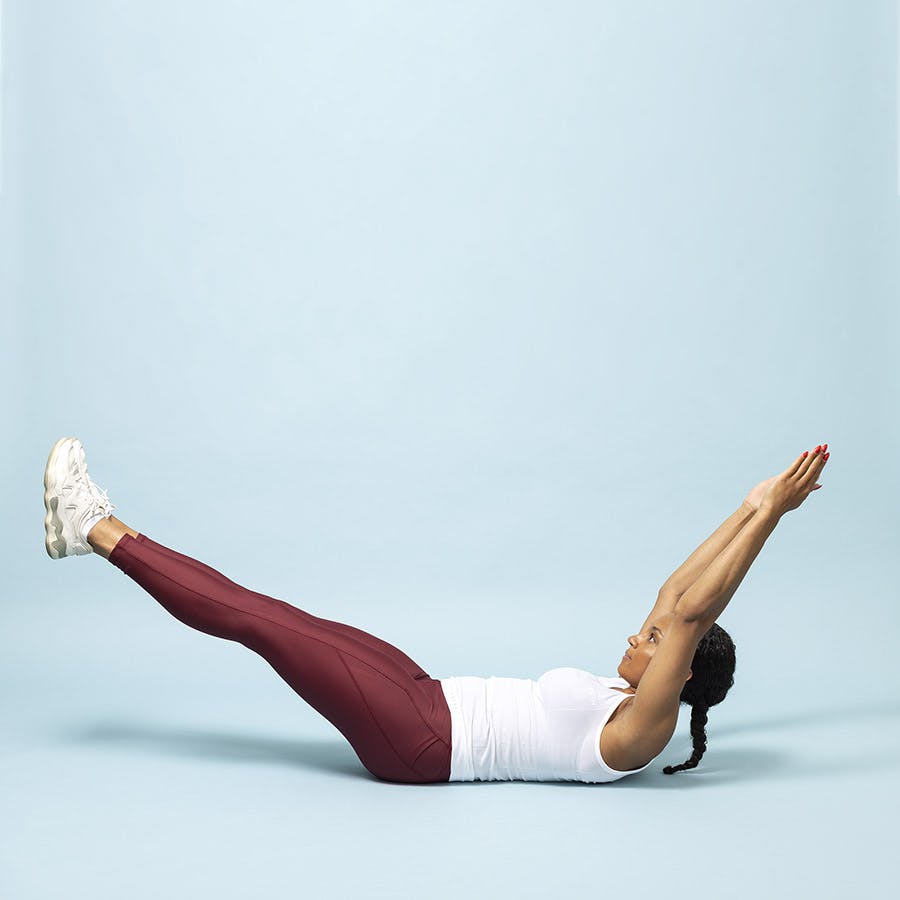 Træner ligger i startposition til maveøvelsen hollow hold