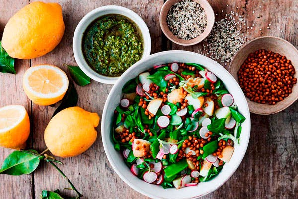 En skål kartoffelsalat med linser, sukkerærter, radiser og pesto.