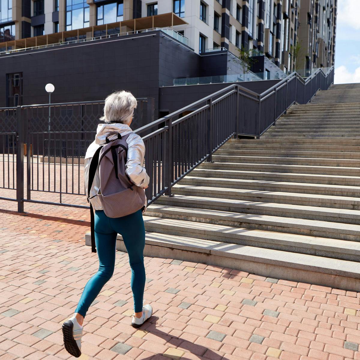 Mogen kvinna på väg mot trappor