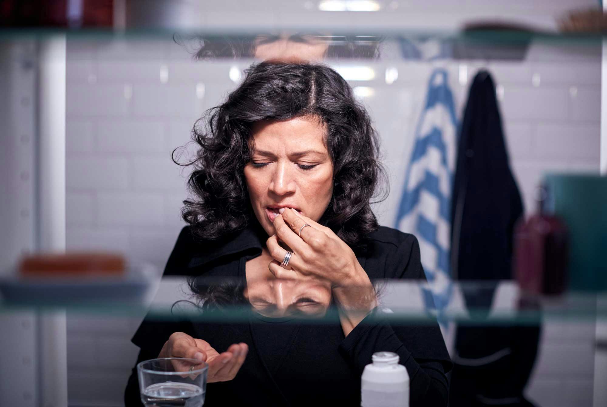 Kvinne på toalettet tar medisin mot diaré