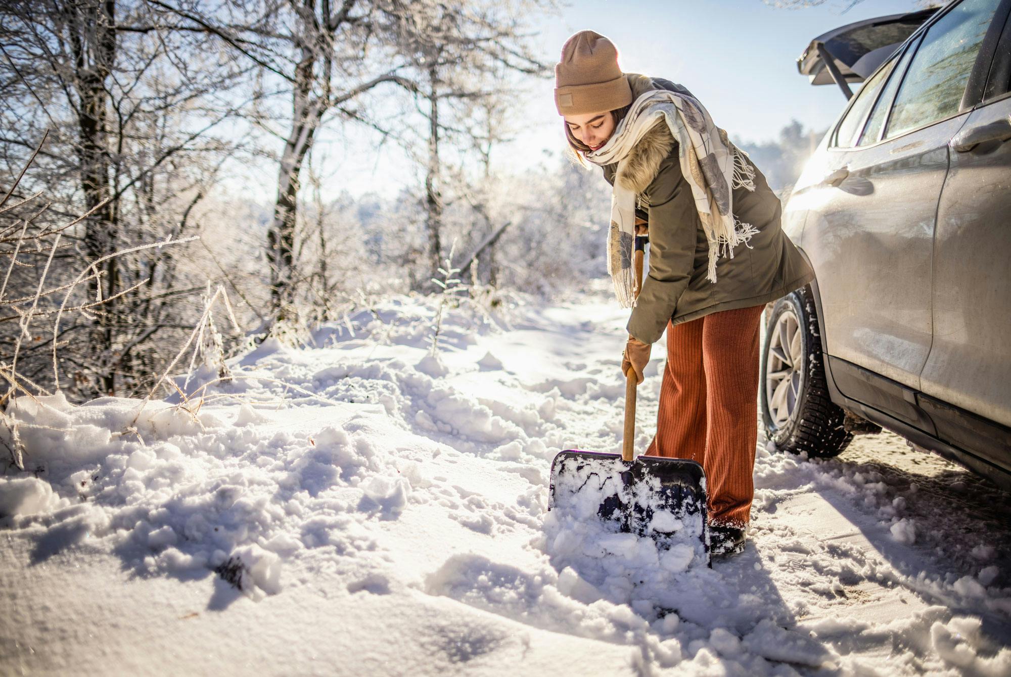 Kvinna som skottar snö